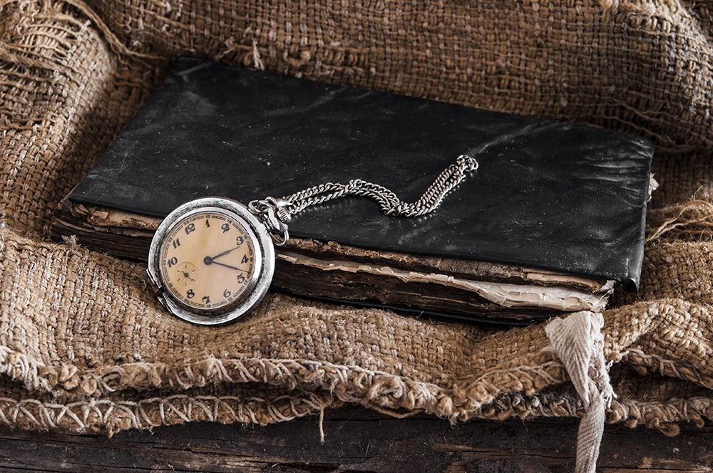 Old pocket watch on a textured vintage background